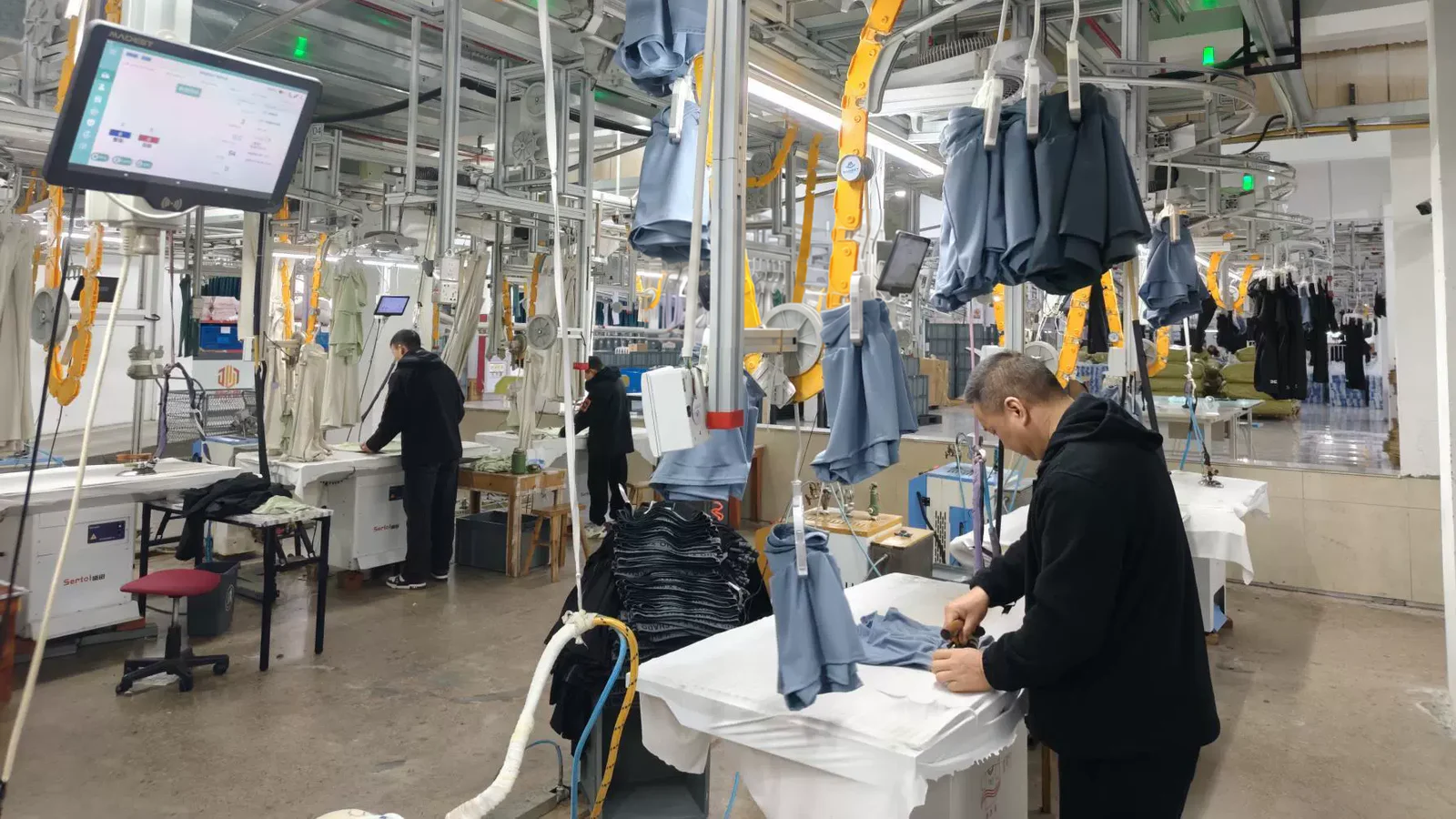 Worker handling garments on the finishing production line